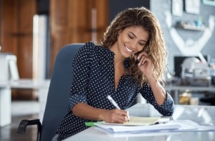 Woman on phone and writing 