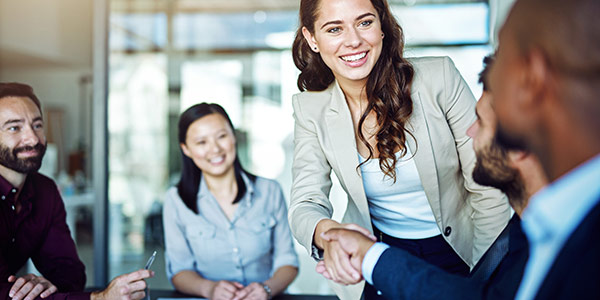 woman shaking hands with man in a group