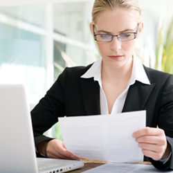 woman in glasses looking at paper 