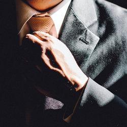 man adjusting tie 