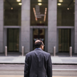 man standing in front of office building