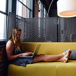 woman working on computer on couch 