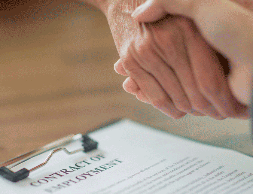 hands shaking over employment contract