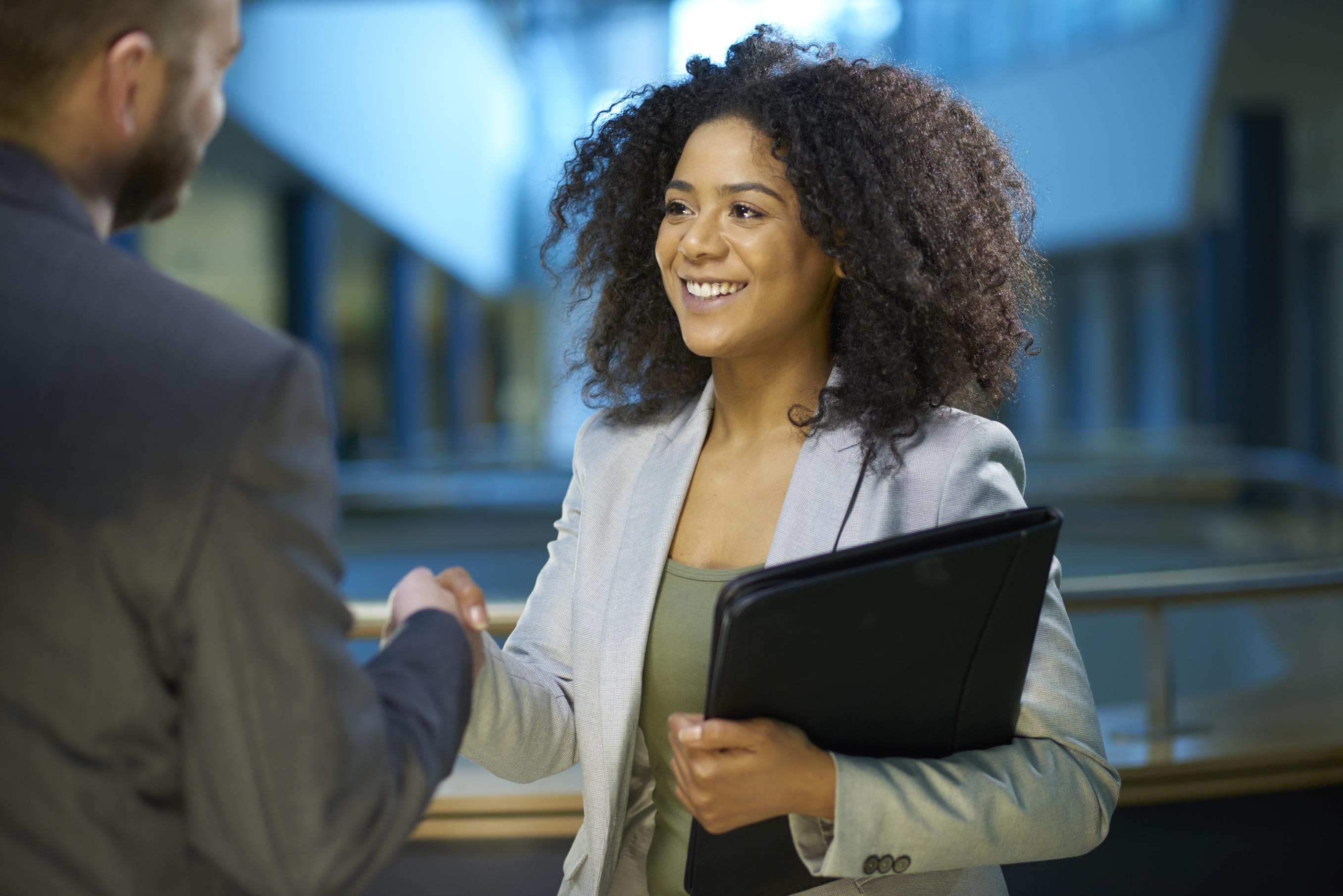 woman shaking hands with man 