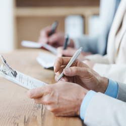 person writing on clipboard