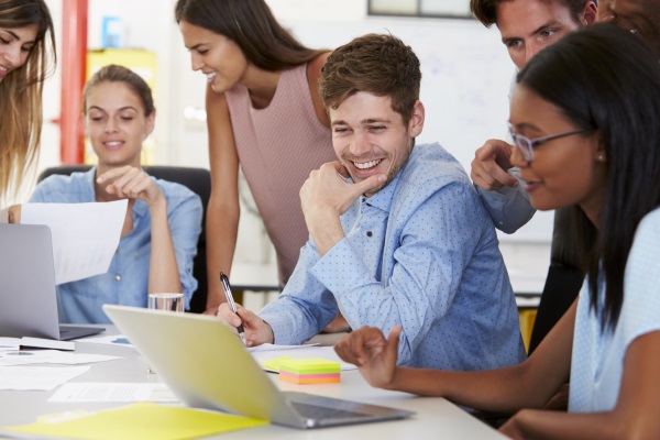 young people gathered around a computer